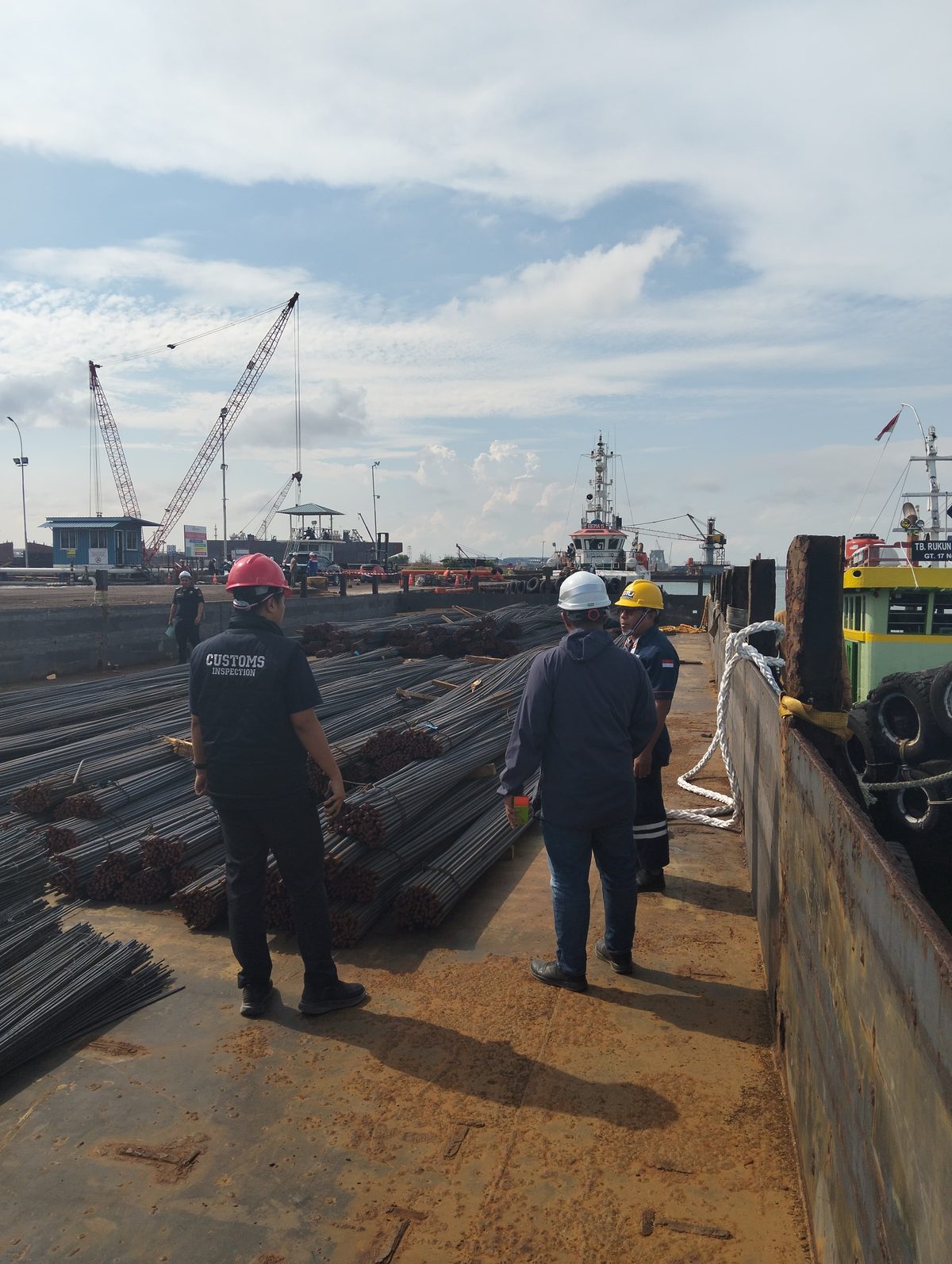 A team standing aboard a barge loaded with rebar